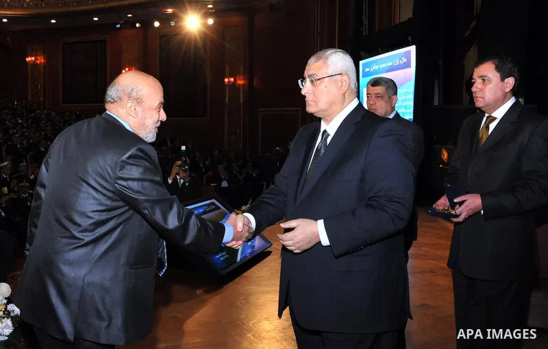 A handout picture released by Egyptian presidency shows Egypt's Interim President Adly Mansour honors the families of Egyptian policemen who were killed in the violence during the celebration of Police Day, in Cairo Janu...