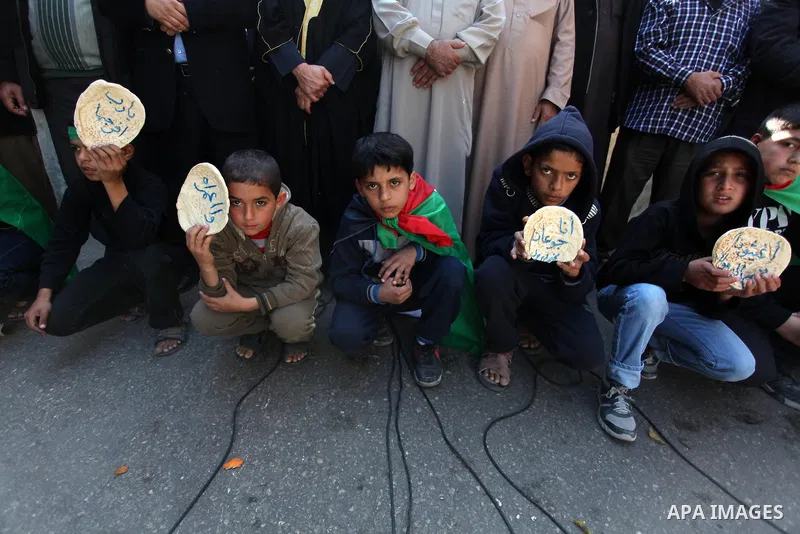 Palestinian supporters of Hamas movement take part in a demonstration in solidarity with Palestinian refugees in the Yarmouk refugee camp in the suburbs of the Syrian capital of Damascus, in Nuseirat camp in central Gaza...