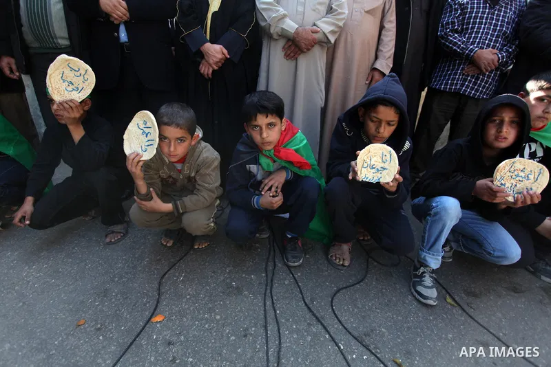Palestinian supporters of Hamas movement take part in a demonstration in solidarity with Palestinian refugees in the Yarmouk refugee camp in the suburbs of the Syrian capital of Damascus, in Nuseirat camp in central Gaza...