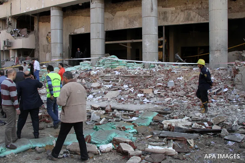 Egyptians inspect the site of a car bomb explosion outside the police headquarters in Cairo on January 24, 2014. A suicide bomber struck Cairo police headquarters in the first of three bombings in the Egyptian capital th...