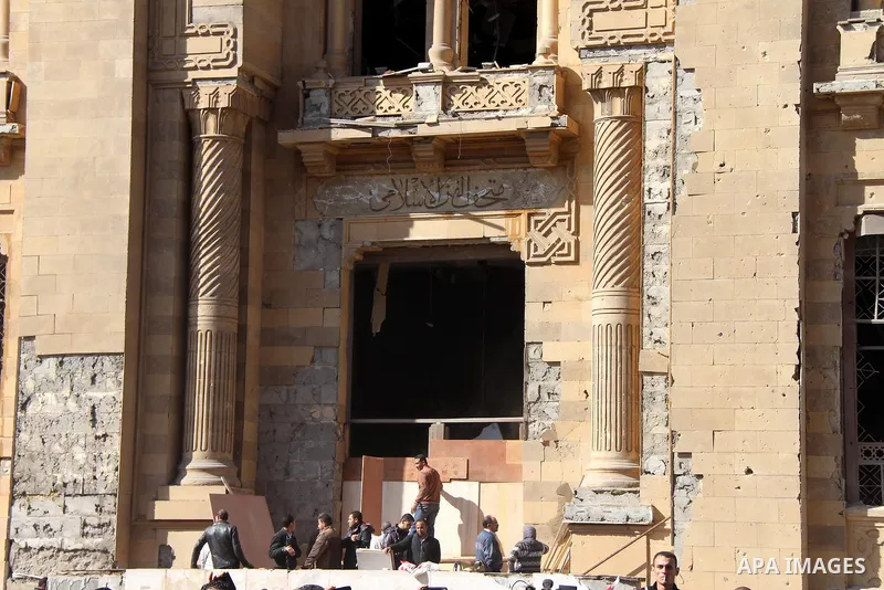 Egyptians inspect the site of a car bomb explosion outside the police headquarters in Cairo on January 24, 2014. A suicide bomber struck Cairo police headquarters in the first of three bombings in the Egyptian capital th...