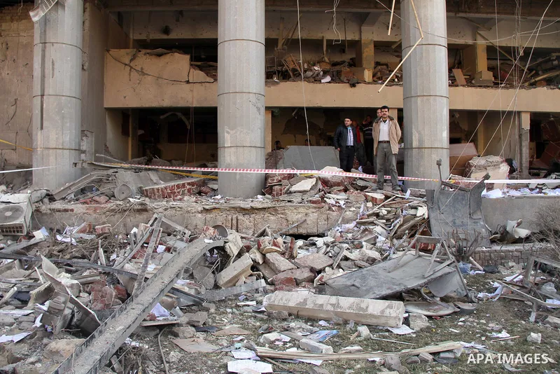 Egyptians inspect the site of a car bomb explosion outside the police headquarters in Cairo on January 24, 2014. A suicide bomber struck Cairo police headquarters in the first of three bombings in the Egyptian capital th...