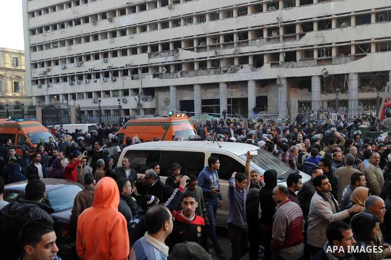 Egyptians inspect the site of a car bomb explosion outside the police headquarters in Cairo on January 24, 2014. A suicide bomber struck Cairo police headquarters in the first of three bombings in the Egyptian capital th...