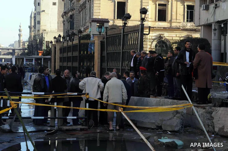 Egyptians inspect the site of a car bomb explosion outside the police headquarters in Cairo on January 24, 2014. A suicide bomber struck Cairo police headquarters in the first of three bombings in the Egyptian capital th...