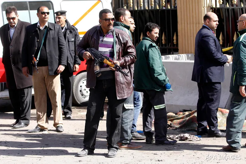 Egyptians inspect the site of a car bomb explosion outside the police headquarters in Cairo on January 24, 2014. A suicide bomber struck Cairo police headquarters in the first of three bombings in the Egyptian capital th...