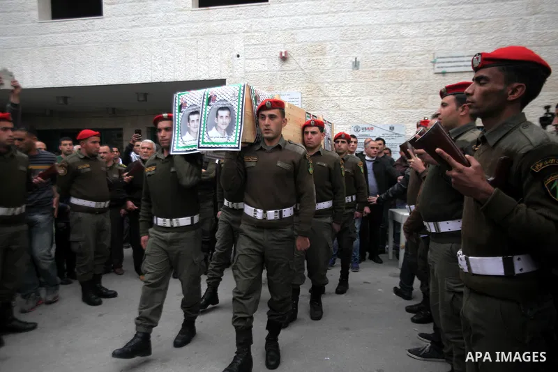 Palestinian security personnel carry a coffin during a funeral in the West Bank city of Bethlehem, 27 January 2014 which are said to contain Palestinian militant Shadi Hamamra who was killed 12 years ago. Israel has star...