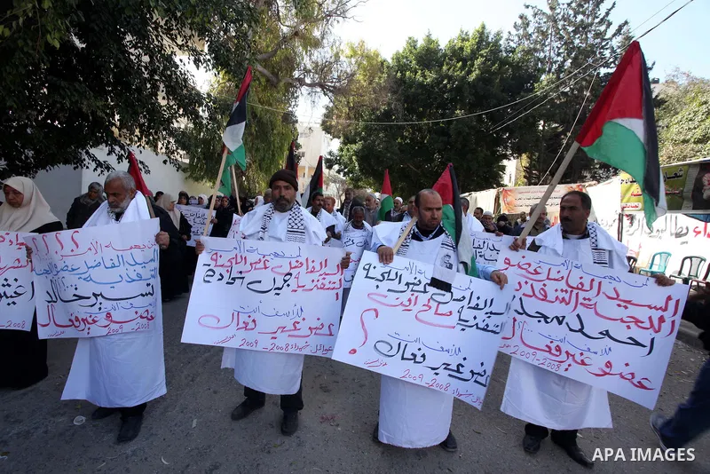 Palestinian families of martyrs who were killed and those that have been wounded in the Israeli-Palestinian conflict in 2008 and 2012, hold placards during a protest against the continued cut of their salaries, in Gaza C...