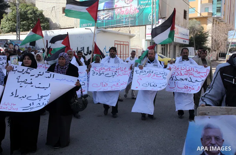 Palestinian families of martyrs who were killed and those that have been wounded in the Israeli-Palestinian conflict in 2008 and 2012, hold placards during a protest against the continued cut of their salaries, in Gaza C...