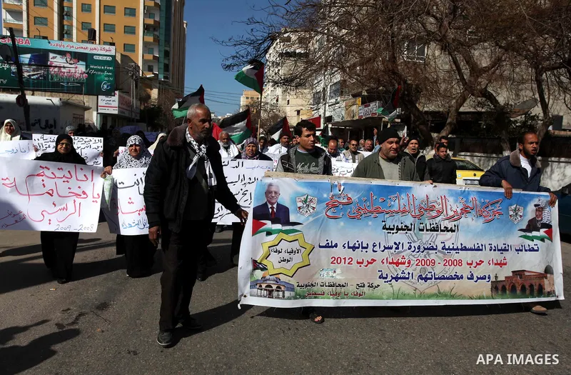 Palestinian families of martyrs who were killed and those that have been wounded in the Israeli-Palestinian conflict in 2008 and 2012, hold placards during a protest against the continued cut of their salaries, in Gaza C...