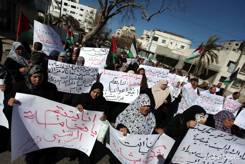 Palestinian families of martyrs who were killed and those that have been wounded in the Israeli-Palestinian conflict in 2008 and 2012, hold placards during a protest against the continued cut of their salaries, in Gaza C...