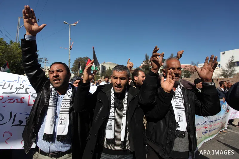 Palestinian families of martyrs who were killed and those that have been wounded in the Israeli-Palestinian conflict in 2008 and 2012, hold placards during a protest against the continued cut of their salaries, in Gaza C...