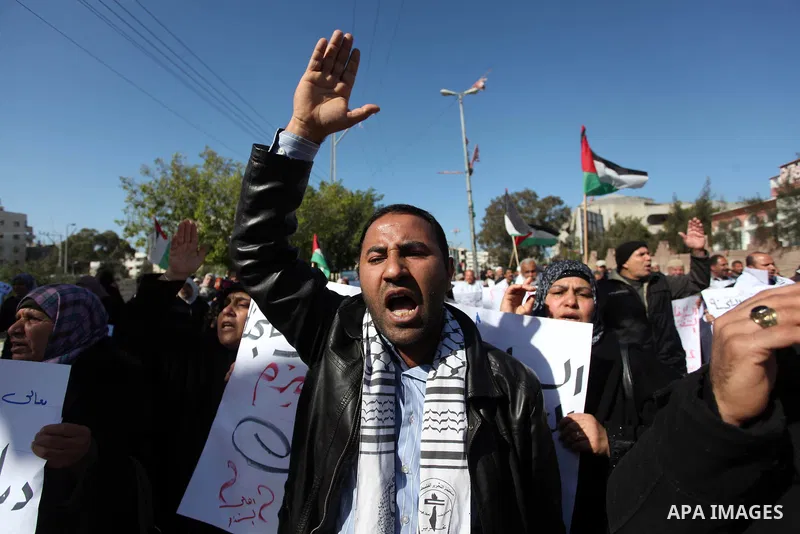 Palestinian families of martyrs who were killed and those that have been wounded in the Israeli-Palestinian conflict in 2008 and 2012, hold placards during a protest against the continued cut of their salaries, in Gaza C...