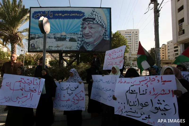 Palestinian families of martyrs who were killed and those that have been wounded in the Israeli-Palestinian conflict in 2008 and 2012, hold placards during a protest against the continued cut of their salaries, in Gaza C...
