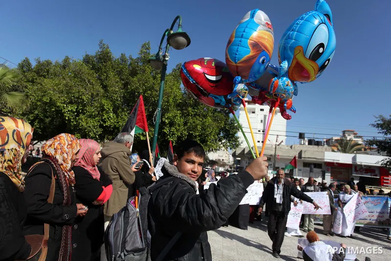 Palestinian families of martyrs who were killed and those that have been wounded in the Israeli-Palestinian conflict in 2008 and 2012, hold placards during a protest against the continued cut of their salaries, in Gaza C...