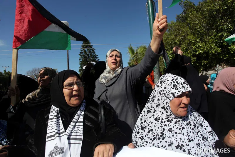 Palestinian families of martyrs who were killed and those that have been wounded in the Israeli-Palestinian conflict in 2008 and 2012, hold placards during a protest against the continued cut of their salaries, in Gaza C...