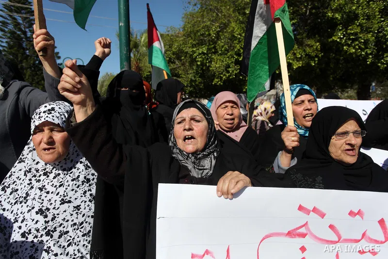 Palestinian families of martyrs who were killed and those that have been wounded in the Israeli-Palestinian conflict in 2008 and 2012, hold placards during a protest against the continued cut of their salaries, in Gaza C...