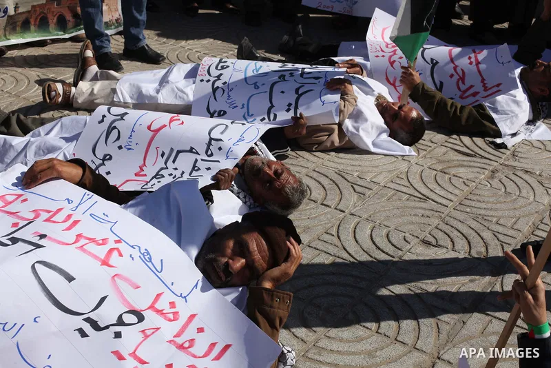 Palestinian families of martyrs who were killed and those that have been wounded in the Israeli-Palestinian conflict in 2008 and 2012, hold placards during a protest against the continued cut of their salaries, in Gaza C...