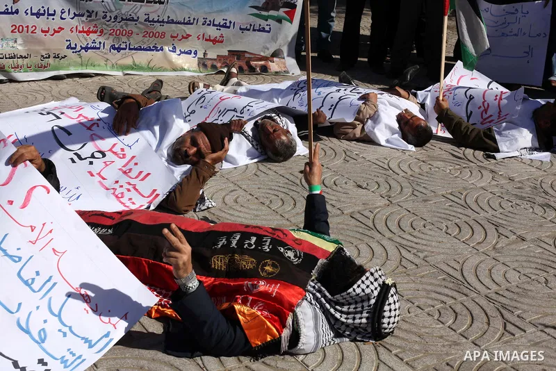 Palestinian families of martyrs who were killed and those that have been wounded in the Israeli-Palestinian conflict in 2008 and 2012, hold placards during a protest against the continued cut of their salaries, in Gaza C...