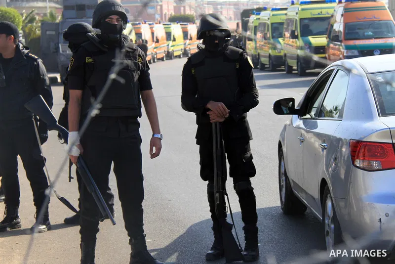 Police and security forces stand guard outside a police academy, where the trial of ousted Egyptian President Mohamed Mursi and members of the Muslim Brotherhood is due to take place, on the outskirts of Cairo, January 2...