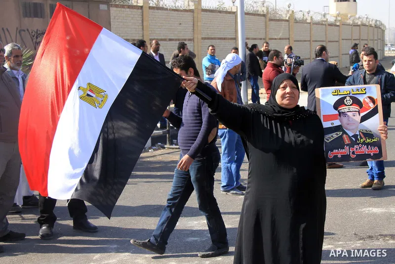 Supporters of Egypt's army chief Field Marshal Abdel Fattah al-Sisi, hold placards during a demonstration outside a police academy on the outskirts of Cairo January 28, 2014, where the trial of ousted Egyptian President...