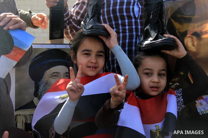 Supporters of Egypt's army chief Field Marshal Abdel Fattah al-Sisi hold military boots on their head as a sign of support for military rule, during a demonstration outside a police academy on the outskirts of Cairo Janu...