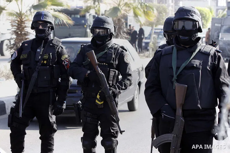 Police and security forces stand guard outside a police academy, where the trial of ousted Egyptian President Mohamed Mursi and members of the Muslim Brotherhood is due to take place, on the outskirts of Cairo, January 2...