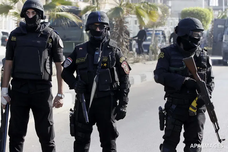 Police and security forces stand guard outside a police academy, where the trial of ousted Egyptian President Mohamed Mursi and members of the Muslim Brotherhood is due to take place, on the outskirts of Cairo, January 2...