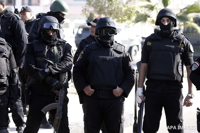 Police and security forces stand guard outside a police academy, where the trial of ousted Egyptian President Mohamed Mursi and members of the Muslim Brotherhood is due to take place, on the outskirts of Cairo, January 2...
