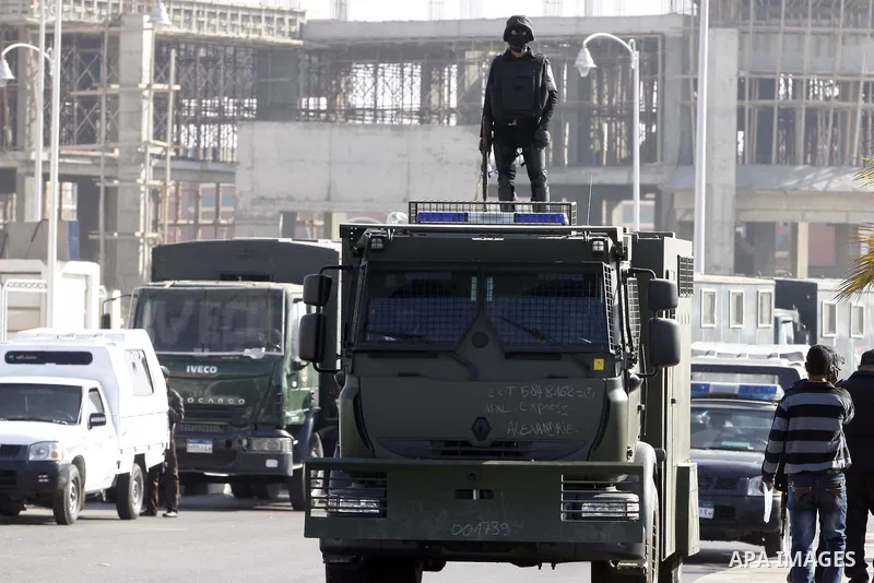 Police and security forces stand guard outside a police academy, where the trial of ousted Egyptian President Mohamed Mursi and members of the Muslim Brotherhood is due to take place, on the outskirts of Cairo, January 2...