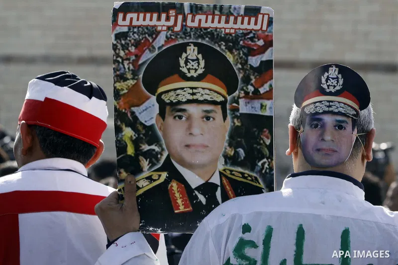 Supporters of Egypt's army chief Field Marshal Abdel Fattah al-Sisi, hold placards during a demonstration outside a police academy on the outskirts of Cairo January 28, 2014, where the trial of ousted Egyptian President...