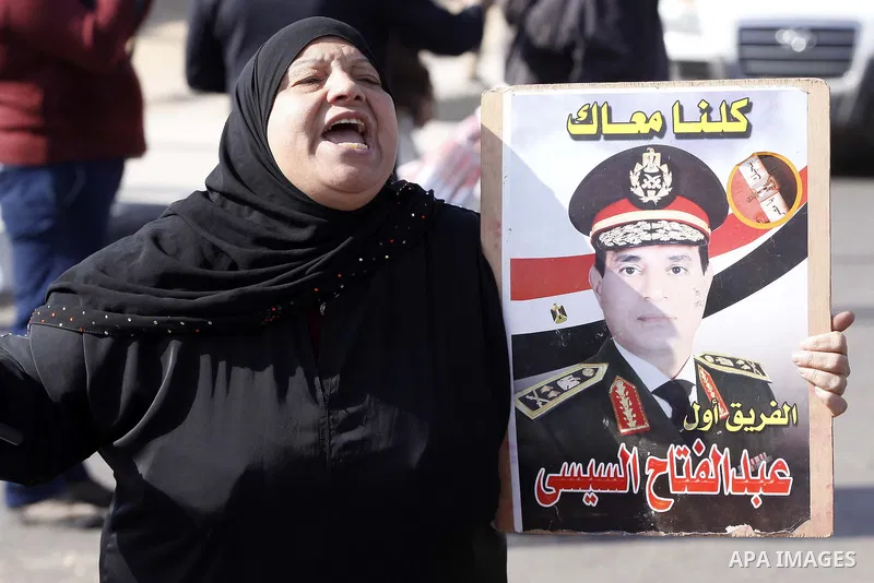 Supporters of Egypt's army chief Field Marshal Abdel Fattah al-Sisi, hold placards during a demonstration outside a police academy on the outskirts of Cairo January 28, 2014, where the trial of ousted Egyptian President...
