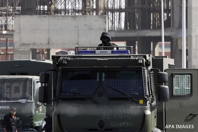 Police and security forces stand guard outside a police academy, where the trial of ousted Egyptian President Mohamed Mursi and members of the Muslim Brotherhood is due to take place, on the outskirts of Cairo, January 2...