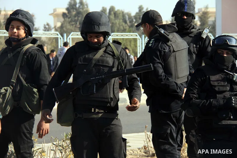 Police and security forces stand guard outside a police academy, where the trial of ousted Egyptian President Mohamed Mursi and members of the Muslim Brotherhood is due to take place, on the outskirts of Cairo, January 2...