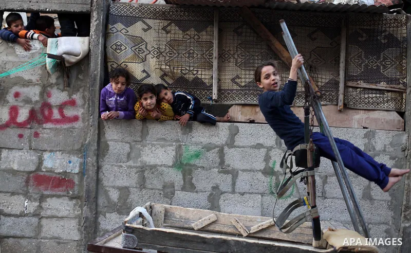 A Palestinian girl plays on a donkey cart in front her Family's house at al-Shati refugee camp in the west Gaza City January 29, 2014. Photo by Ashraf Amra