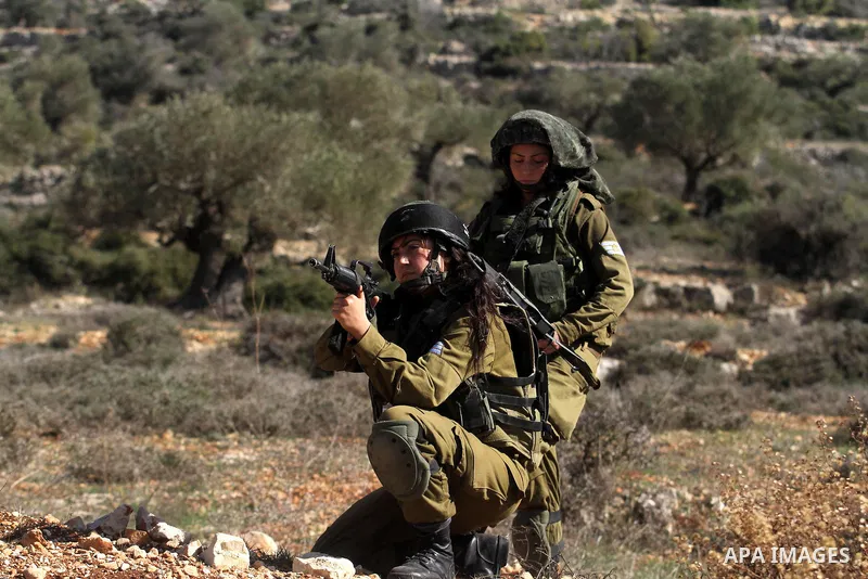 Israeli soldiers stand guard near the site of a fatal shooting incident next to the Palestinian village of Ein Sariya, north of the West Bank city of Ramallah January 29, 2014. Israeli soldiers killed Muhammad Mubarak, 2...