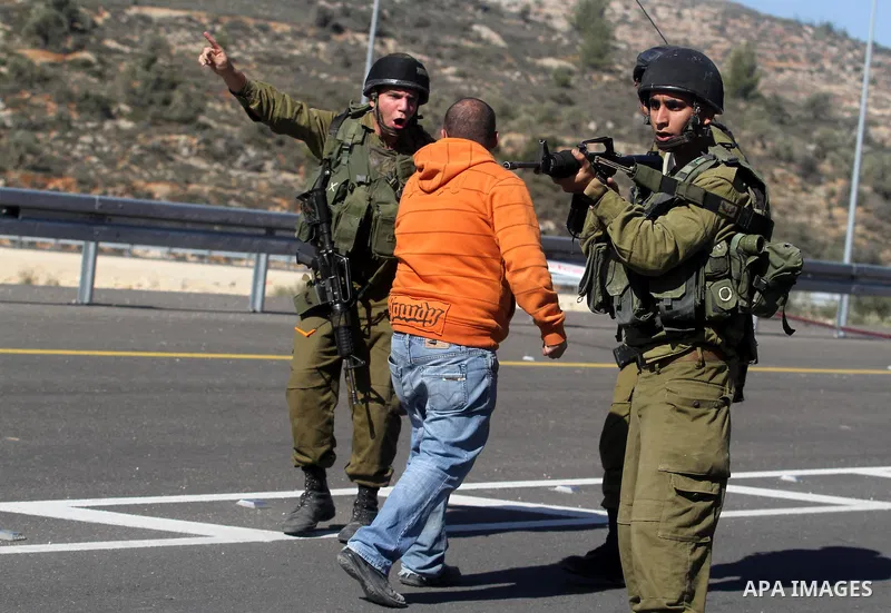 A Palestinian man argues with Israeli soldiers as they guard near the site of a fatal shooting incident next to the Palestinian village of Ein Sariya, north of the West Bank city of Ramallah January 29, 2014. Israeli sol...