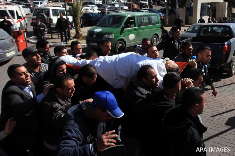 Palestinian relatives of Muhammad Mubarak, 21, carry his body during a funeral in the West Bank city of Ramallah January 29, 2014. Israeli soldiers killed Mubarak on Wednesday who the military said had opened fire on the...
