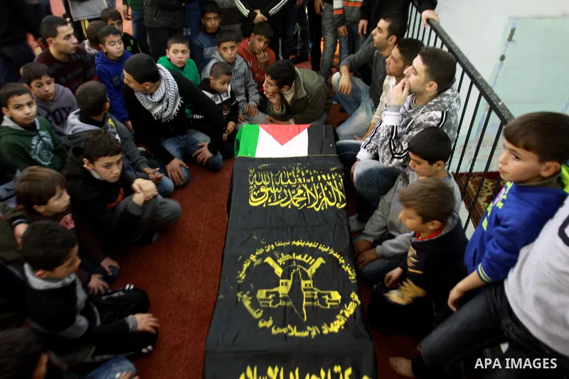 Palestinian children gather around the coffin of Abdulkareem Tahaina killed in 2002 by Israeli Army after his remains were returned in West Bank city of Jenin on Jan. 29 2014. Israel planed to return the bodies of 36 Pal...