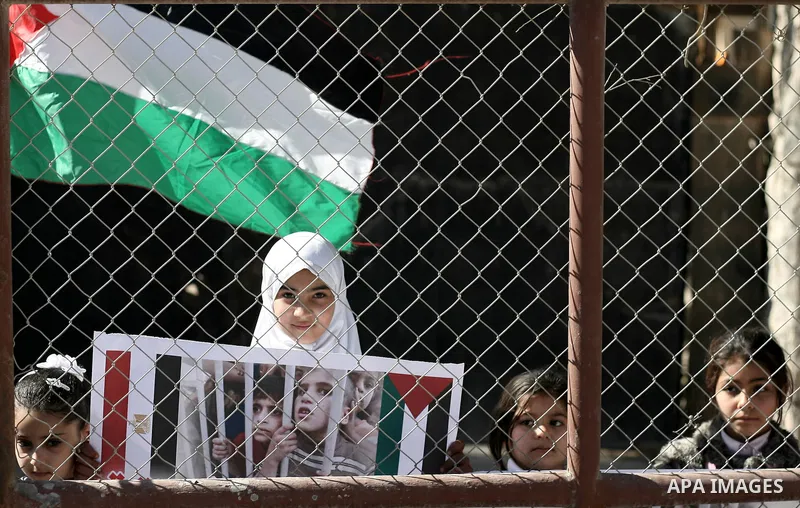 Palestinian children carry placards during a rally in front of the Rafah border crossing with Egypt in the southern Gaza Strip on January 29, 2014, demanding the permanent and unconditional opening of the crossing. Egypt...
