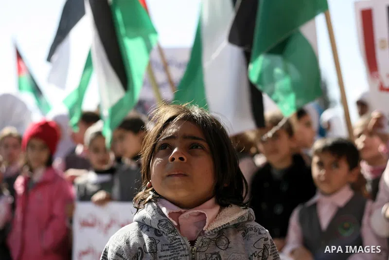 Palestinian children carry placards during a rally in front of the Rafah border crossing with Egypt in the southern Gaza Strip on January 29, 2014, demanding the permanent and unconditional opening of the crossing. Egypt...