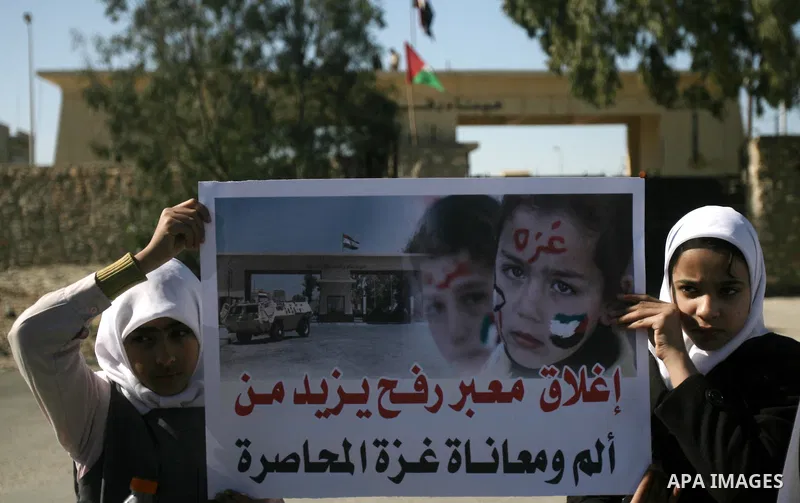Palestinian children carry placards during a rally in front of the Rafah border crossing with Egypt in the southern Gaza Strip on January 29, 2014, demanding the permanent and unconditional opening of the crossing. Egypt...