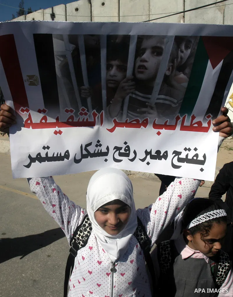 Palestinian children carry placards during a rally in front of the Rafah border crossing with Egypt in the southern Gaza Strip on January 29, 2014, demanding the permanent and unconditional opening of the crossing. Egypt...