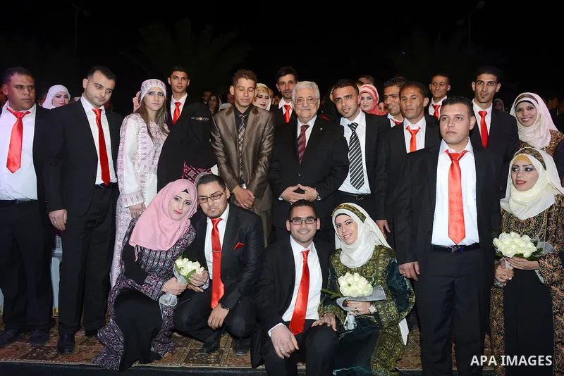 Palestinian Authority President Mahmud Abbas with couples pose for a photograph during a mass wedding ceremony in the West bank city of Jericho on January 28, 2014. Nearly 300 Palestinians were married in the West Bank a...