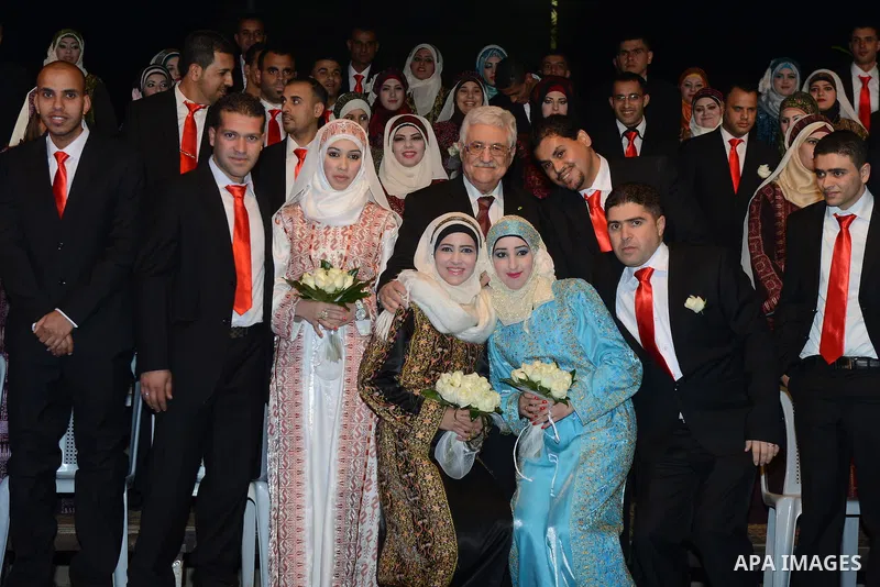 Palestinian Authority President Mahmud Abbas with couples pose for a photograph during a mass wedding ceremony in the West bank city of Jericho on January 28, 2014. Nearly 300 Palestinians were married in the West Bank a...