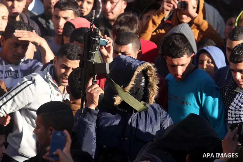 A Palestinian gunman holds his weapon during the funeral of Mohammad Mubarak, 18, in the Jalazoun refugee camp near the West Bank city of Ramallah, Wednesday, Jan. 29, 2014. Israeli troops shot Mubarak to death on Wednes...