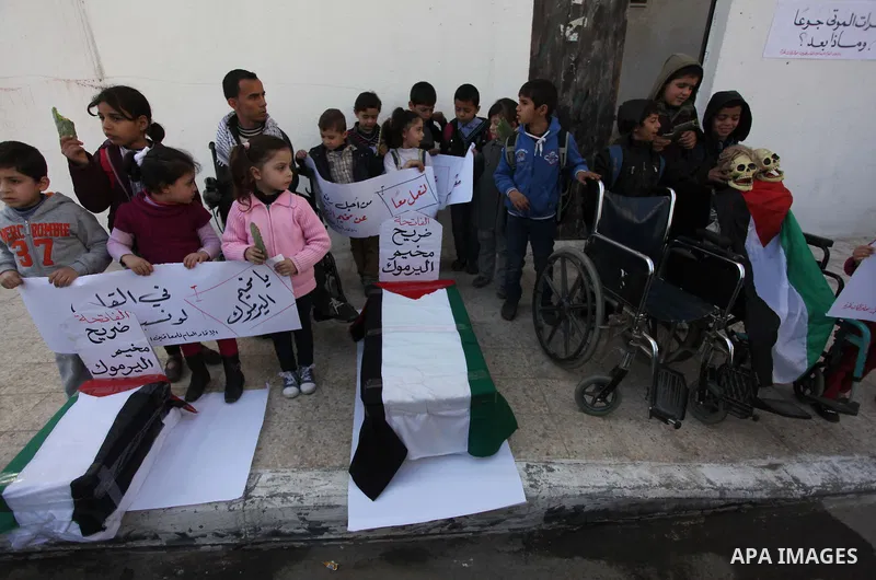 Palestinian children take part in a protest to show solidarity with Palestinian refugees Syria's main refugee camp Yarmouk, in Gaza City on January 30, 2014. Photo by Ashraf Amra