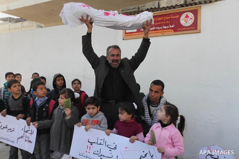 Palestinian children take part in a protest to show solidarity with Palestinian refugees Syria's main refugee camp Yarmouk, in Gaza City on January 30, 2014. Photo by Ashraf Amra