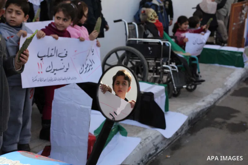 Palestinian children take part in a protest to show solidarity with Palestinian refugees Syria's main refugee camp Yarmouk, in Gaza City on January 30, 2014. Photo by Ashraf Amra
