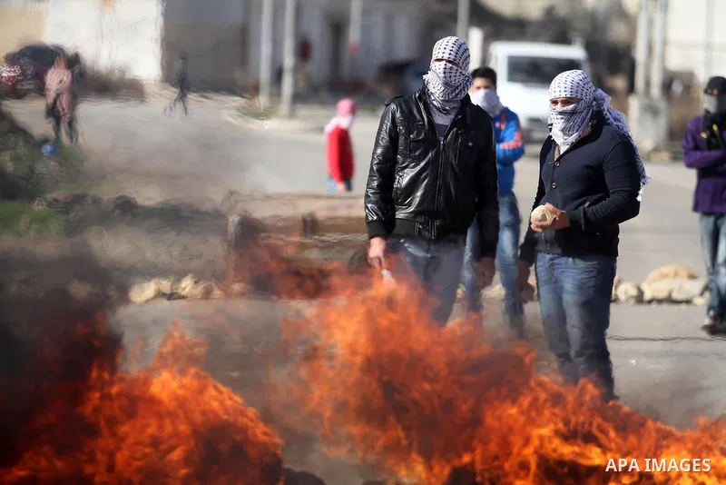 Palestinian students from Bir Zeit University burn tires during clashes with Israeli border police on January 30, 2014 near the Israeli detention center of Ofer, in the occupied West Bank. The students were protesting on...