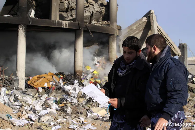 Palestinian policemen inspect a building destroyed by an Israeli airstrike in Beit Lahia, northern Gaza Strip, on January 30, 2014. Israeli fighter jets attacked training sites of Ezzedine al-Qassam Brigades, Hamas's arm...
